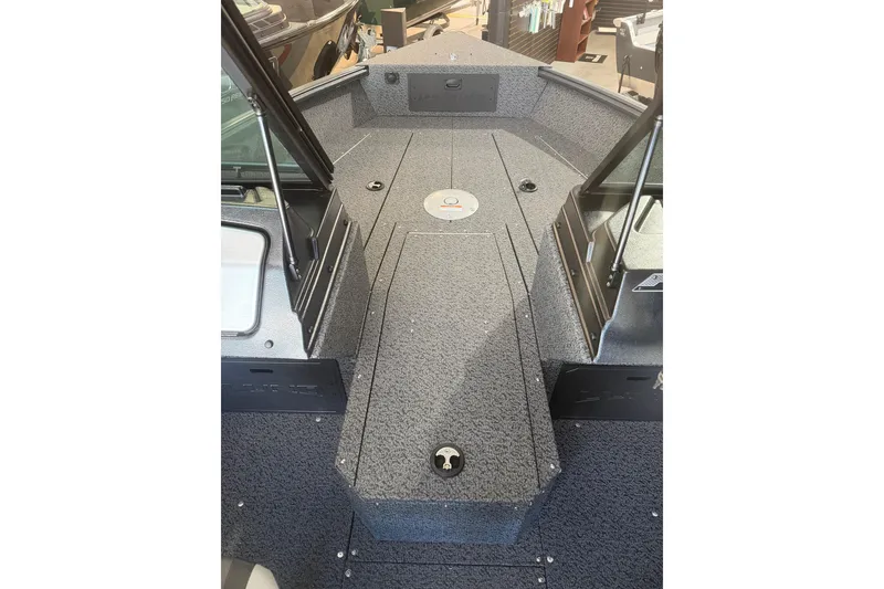 Slide: The Image of 2027 Lund 1700 Explorer Sport boat interior with gray textured flooring and storage compartments. - 14