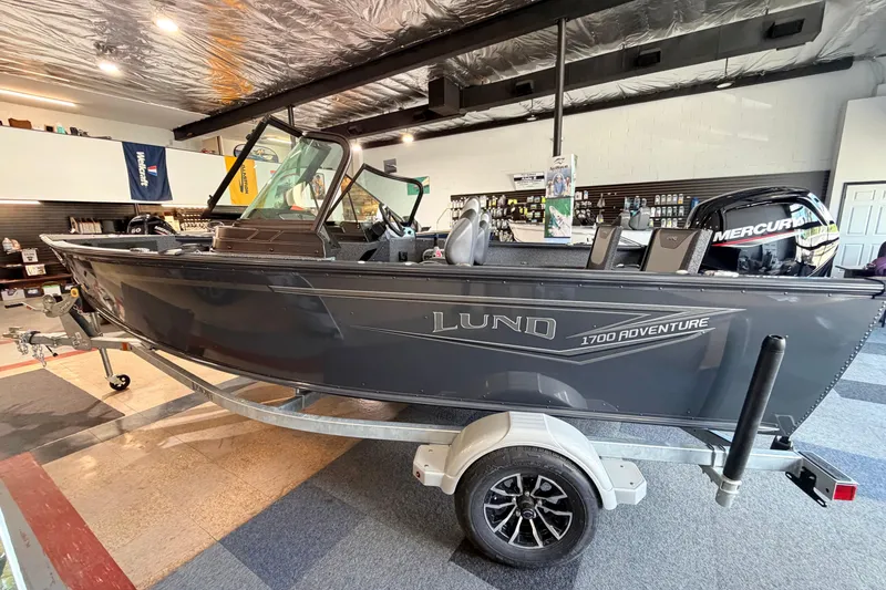 The Image of 2027 Lund 1700 Explorer Sport boat displayed indoors on a trailer. - 0