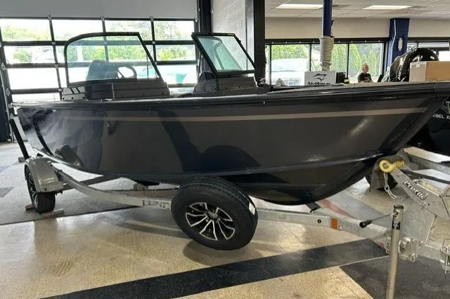 The Image of 2027 Lund 1700 Explorer Sport boat on trailer in showroom setting. - 1