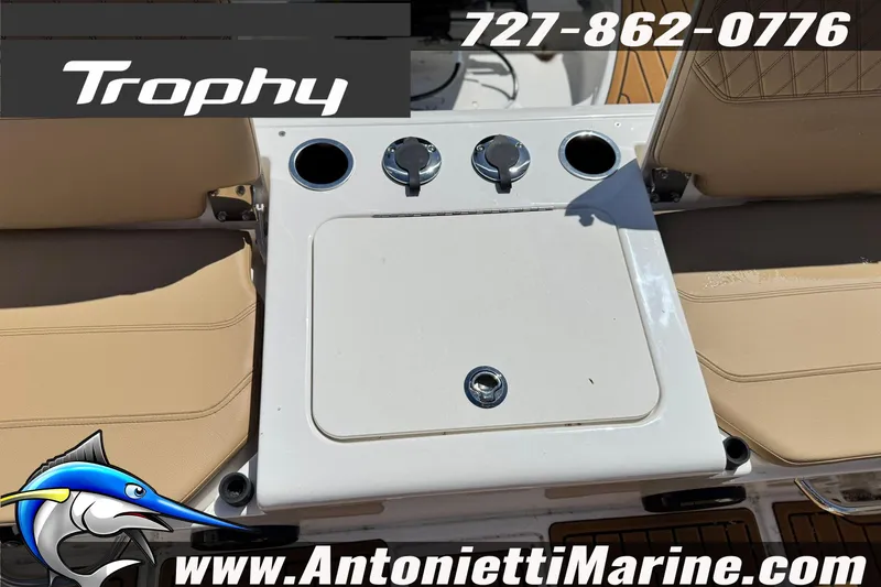 Slide: The Image of 2026 Bayliner Trophy T20CC boat seating area with cup holders and storage compartment. - 13