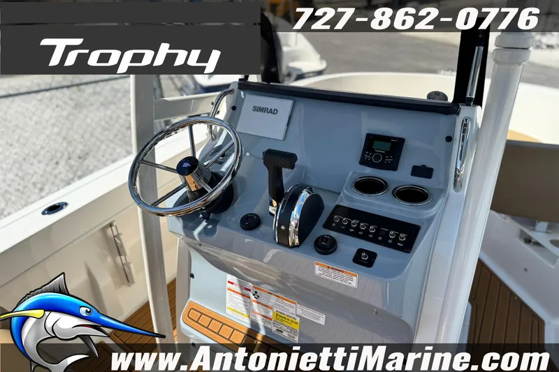 Slide: The Image of 2026 Bayliner Trophy T20CC boat dashboard with steering wheel and controls, featuring Simrad electronics. - 17