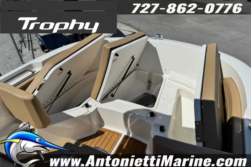 Slide: The Image of 2026 Bayliner Trophy T20CC boat interior with open storage compartments, featuring tan seating. - 30