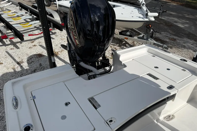 Slide: The Image of 2025 Tidewater 2300 Carolina Bay boat with powerful outboard motor, parked on gravel. - 4