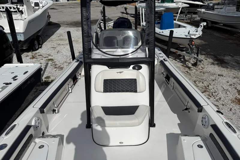 Slide: The Image of 2025 Tidewater 2300 Carolina Bay boat interior, featuring seating and console, in a marina setting. - 9
