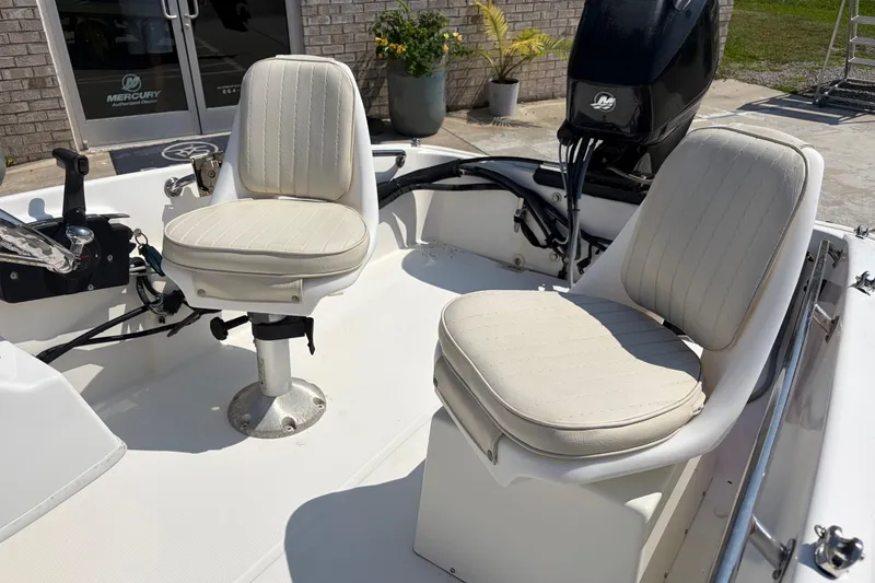 Slide: The Image of 2011 Boston Whaler 130 Super Sport boat interior with two cushioned seats and Mercury engine. - 9