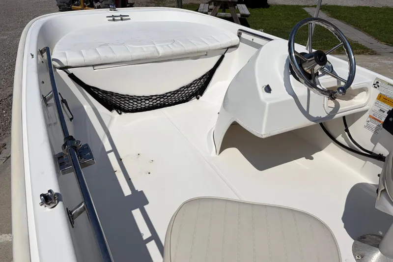 Slide: The Image of 2011 Boston Whaler 130 Super Sport boat interior with steering wheel and seating. - 12