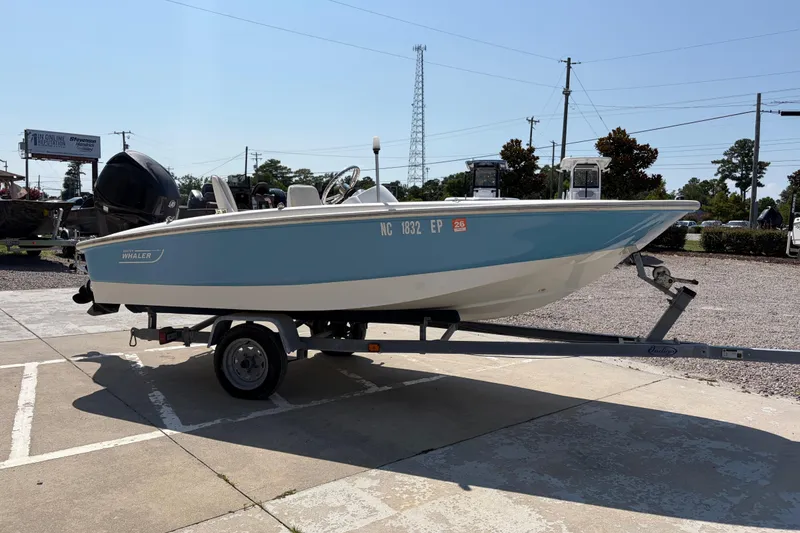 Slide: The Image of 2011 Boston Whaler 130 Super Sport boat on trailer, parked outdoors. - 6
