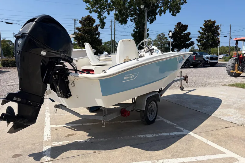 Slide: The Image of 2011 Boston Whaler 130 Super Sport boat on trailer, parked outdoors. - 5