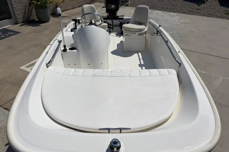 Slide: The Image of 2011 Boston Whaler 130 Super Sport boat with white interior, parked on concrete surface. - 7