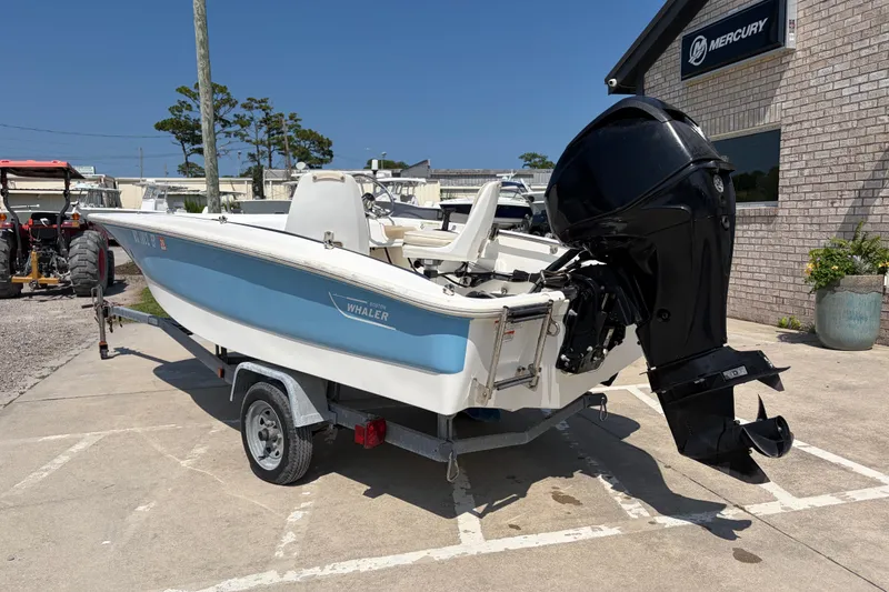 Slide: The Image of 2011 Boston Whaler 130 Super Sport boat with outboard motor on trailer. - 3