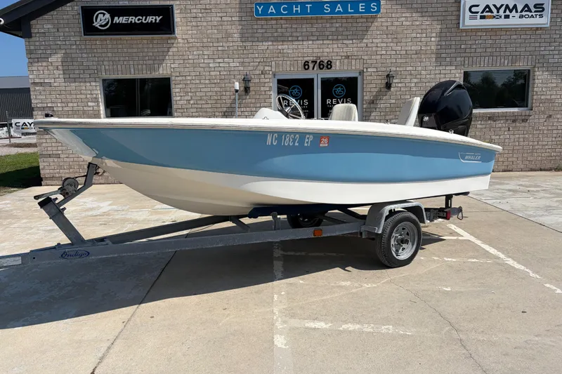 The Image of 2011 Boston Whaler 130 Super Sport boat on trailer outside yacht sales building. - 1