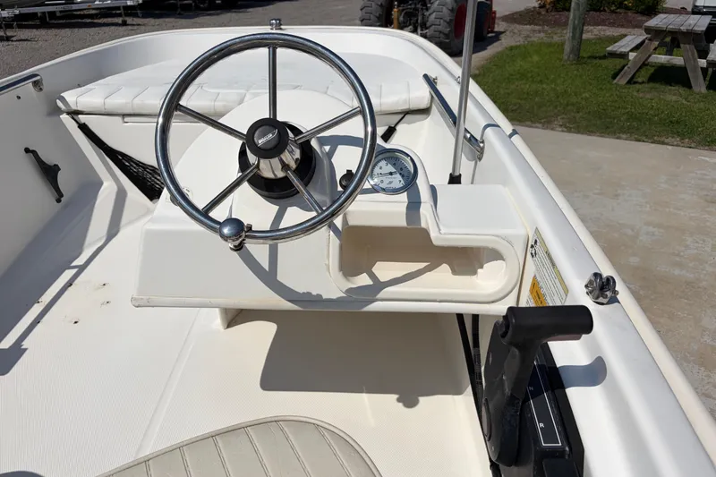 Slide: The Image of 2011 Boston Whaler 130 Super Sport boat interior with steering wheel and gauge. - 11