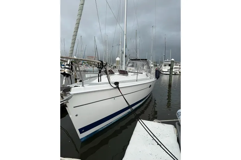 Slide: The Image of 2004 Hunter 466 sailboat docked in a marina under cloudy skies. - 4