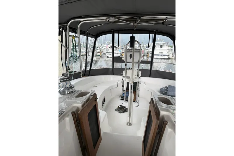 Slide: The Image of Interior view of a 2004 Hunter 466 sailboat cockpit with marina background. - 8