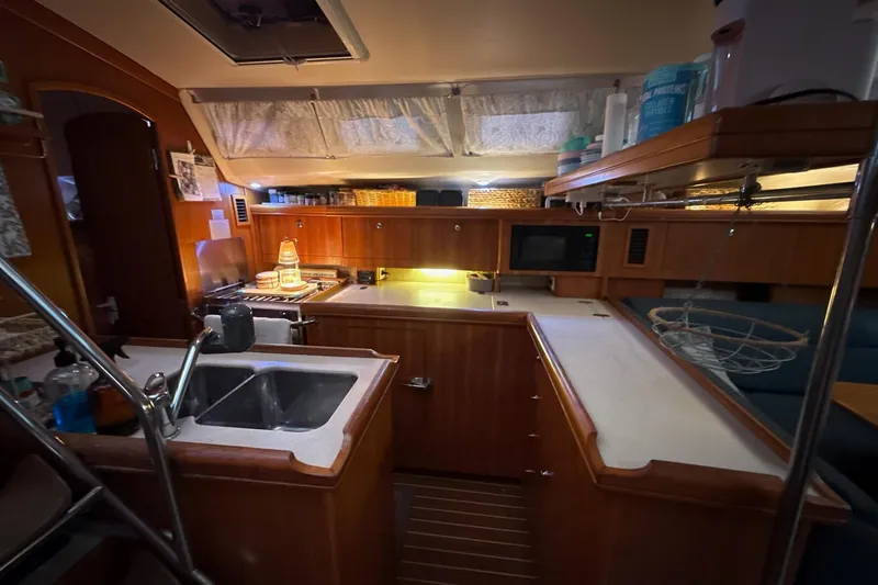 Slide: The Image of Interior of a 2004 Hunter 466 yacht kitchen with wooden cabinetry and modern appliances. - 13