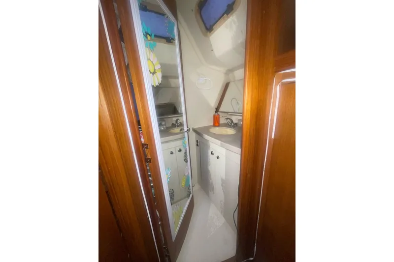 Slide: The Image of Interior of 2004 Hunter 466 sailboat bathroom with wooden door and compact sink area. - 19