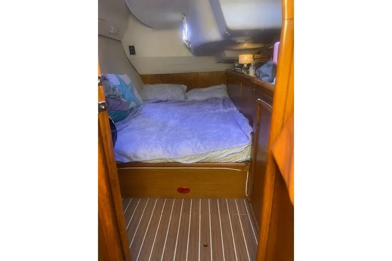 Slide: The Image of Cozy cabin interior of 2004 Hunter 466 sailboat with wooden finish and comfortable bedding. - 21