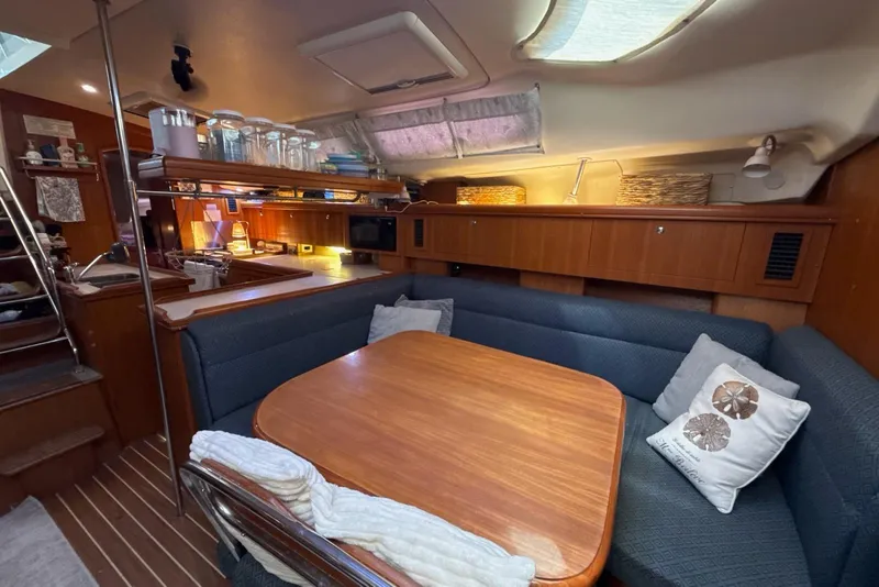 Slide: The Image of Interior of a 2004 Hunter 466 sailboat with cozy dining area and wooden table. - 15