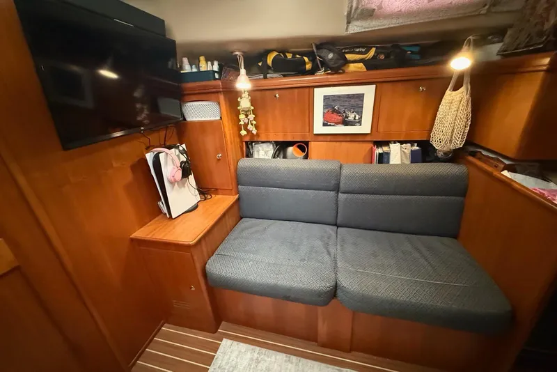 Slide: The Image of Cozy interior of 2004 Hunter 466 yacht with seating, TV, and storage. - 14