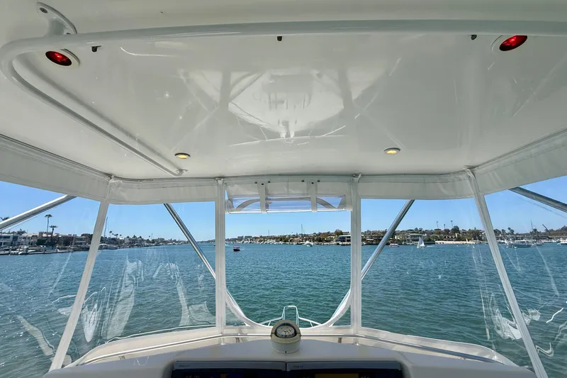 Slide: The Image of View from 2004 Cabo 35 Flybridge boat, overlooking a serene harbor with clear skies. - 44
