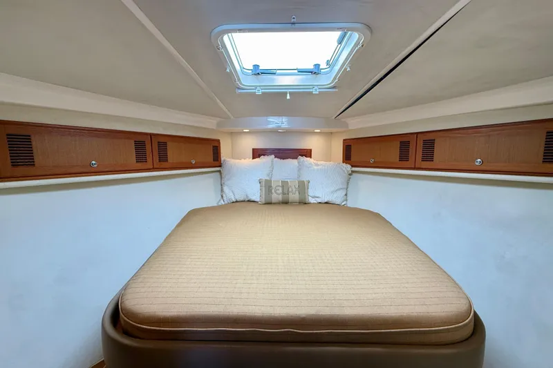 Slide: The Image of Luxurious cabin interior of 2004 Cabo 35 Flybridge with cozy bed and skylight. - 11