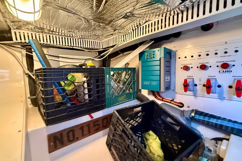 Slide: The Image of Electrical panel and storage area inside a 2004 Cabo 35 Flybridge boat. - 71