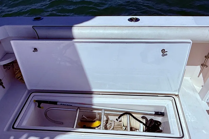 Slide: The Image of Open storage compartment on 2004 Cabo 35 Flybridge boat, containing marine equipment. - 56