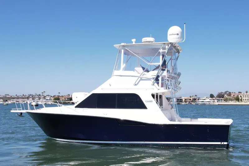 Slide: The Image of 2004 Cabo 35 Flybridge yacht on calm water, clear sky background. - 6