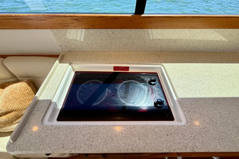 Slide: The Image of 2004 Cabo 35 Flybridge yacht kitchen with electric stove and ocean view. - 21