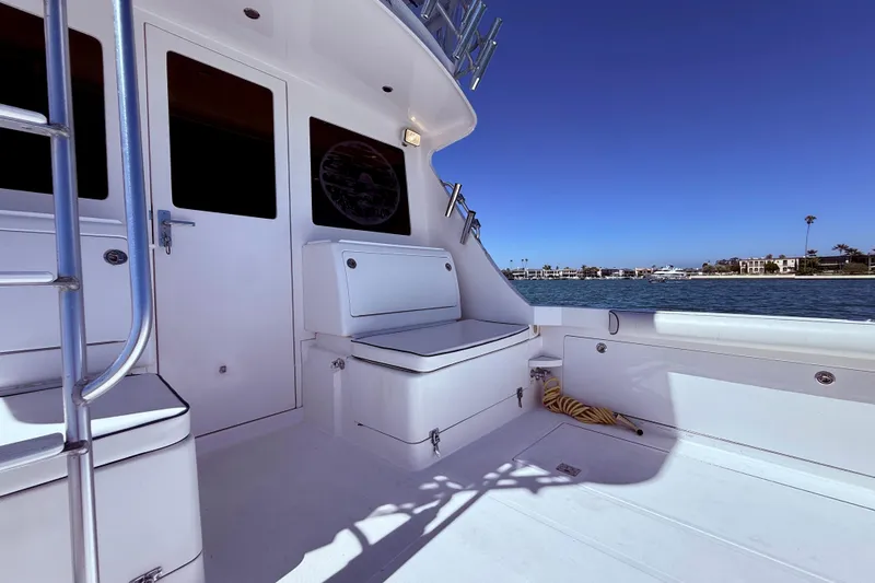 Slide: The Image of 2004 Cabo 35 Flybridge boat deck with seating, ladder, and ocean view. - 53
