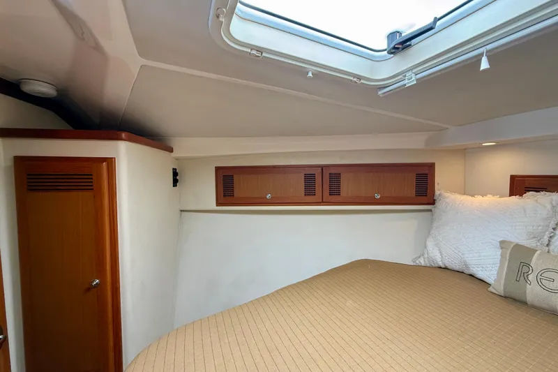 Slide: The Image of Interior cabin of 2004 Cabo 35 Flybridge with cozy bedding and wooden storage. - 13