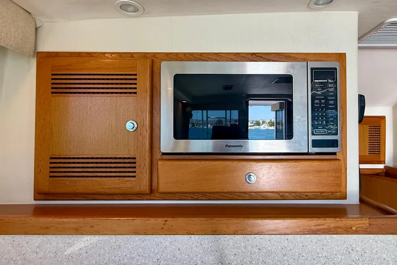 Slide: The Image of Built-in microwave and wooden cabinet in 2004 Cabo 35 Flybridge yacht interior. - 23