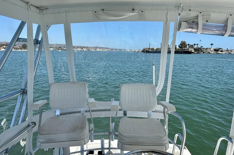 Slide: The Image of Flybridge view from a 2004 Cabo 35, overlooking calm waters and distant shoreline. - 42