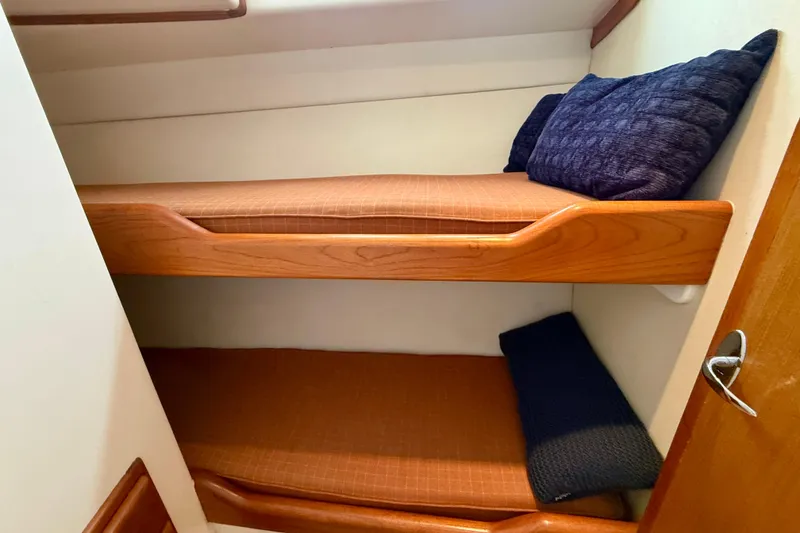 Slide: The Image of Bunk beds in 2004 Cabo 35 Flybridge cabin with wooden frames and cushions. - 10