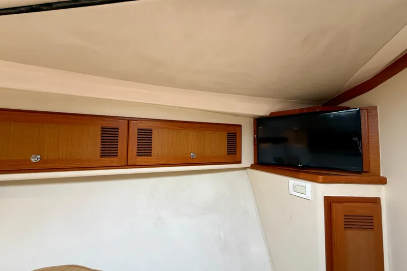 Slide: The Image of Interior of 2004 Cabo 35 Flybridge with wooden cabinets and mounted TV. - 12