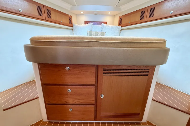 Slide: The Image of Interior cabin of 2004 Cabo 35 Flybridge with wooden storage and cushioned seating. - 15