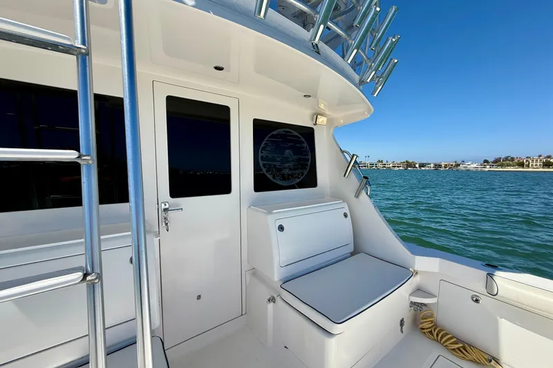 Slide: The Image of 2004 Cabo 35 Flybridge boat deck with seating, ladder, and ocean view. - 48