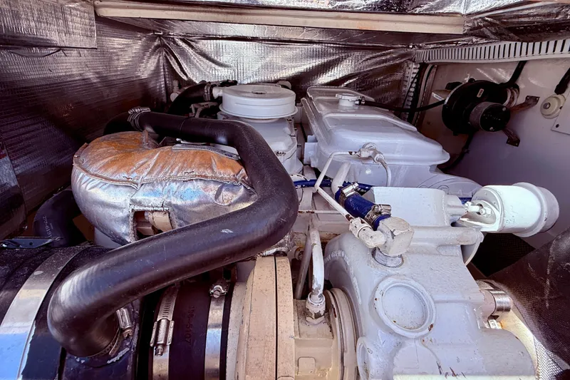 Slide: The Image of Engine compartment of a 2004 Cabo 35 Flybridge boat, showcasing mechanical components. - 61