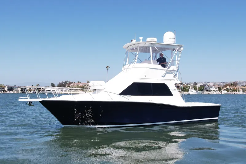 Slide: The Image of 2004 Cabo 35 Flybridge yacht cruising on calm waters under clear blue sky. - 7
