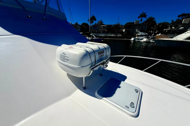 Slide: The Image of 2004 Cabo 35 Flybridge boat deck with life raft, docked in marina. - 68