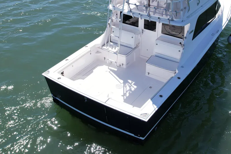 Slide: The Image of 2004 Cabo 35 Flybridge boat on water, featuring spacious deck and seating area. - 5