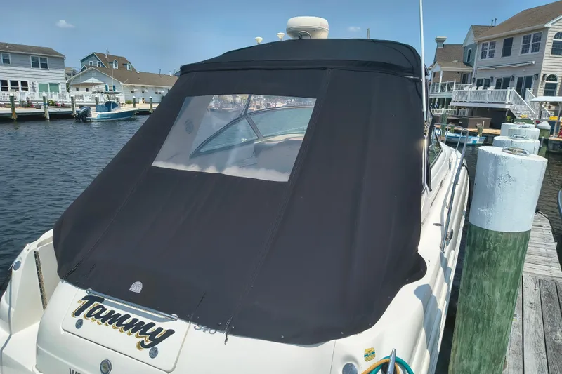 Slide: The Image of 2001 Sea Ray 340 Sundancer docked with black canvas cover in a marina setting. - 3