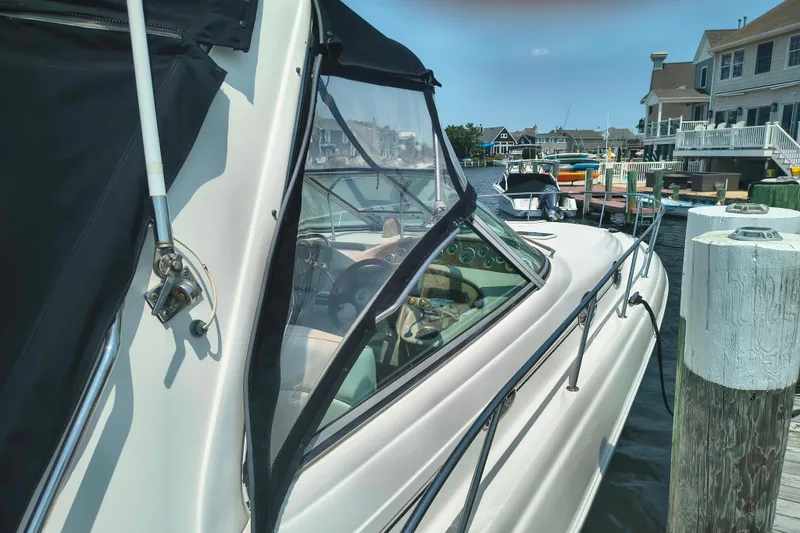 Slide: The Image of 2001 Sea Ray 340 Sundancer docked at a marina, showcasing sleek design and waterfront homes. - 2