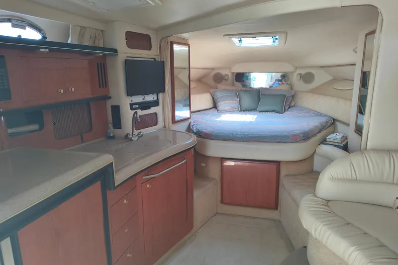 Slide: The Image of Interior of 2001 Sea Ray 340 Sundancer with cozy bed, kitchenette, and seating area. - 10