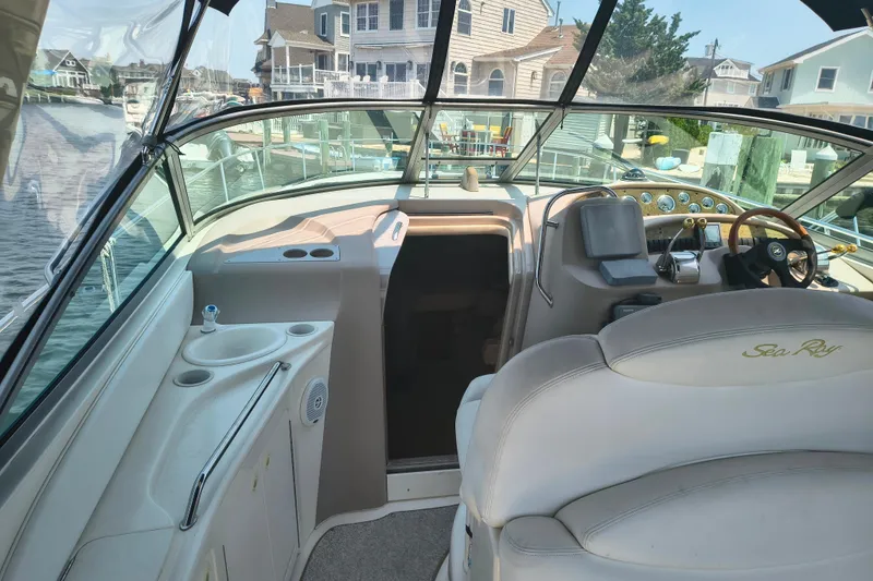 Slide: The Image of 2001 Sea Ray 340 Sundancer cockpit with helm, seating, and waterfront view. - 4