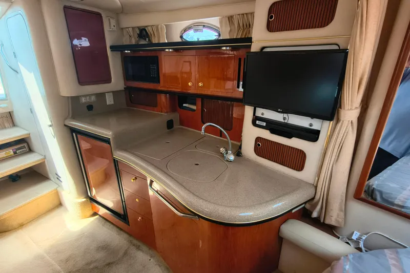 Slide: The Image of Interior of a 2001 Sea Ray 340 Sundancer yacht with kitchenette and TV. - 12