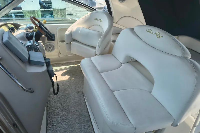 Slide: The Image of Interior of a 2001 Sea Ray 340 Sundancer boat with white seating and steering area. - 7