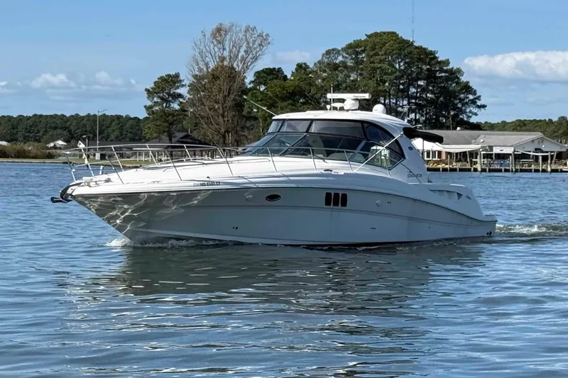 The Image of 2007 Sea Ray 44 Sundancer yacht cruising on a serene lake with trees in the background. - 0