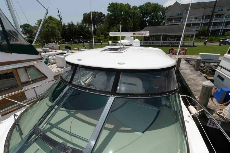 Slide: The Image of 2007 Sea Ray 44 Sundancer yacht docked at marina, showcasing sleek design and spacious deck. - 10