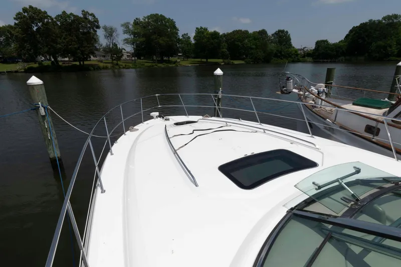 Slide: The Image of 2007 Sea Ray 44 Sundancer yacht docked on a calm river with lush greenery. - 12